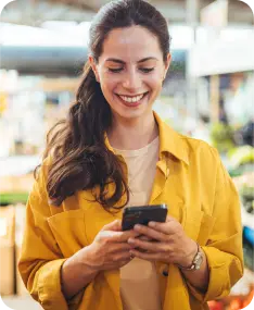 Cliente sorridente usando smartphone para acessar atendimento online.